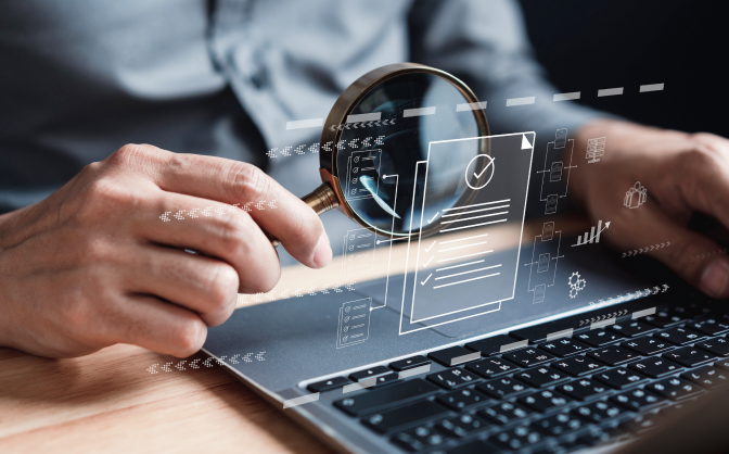 GMF e IVA Banca de inversión Imagen de un teclado de computador portátil y una mano sosteniendo una lupa para ver y analizar las métricas en realidad aumentada del GMF e IVA Banca de inversión.